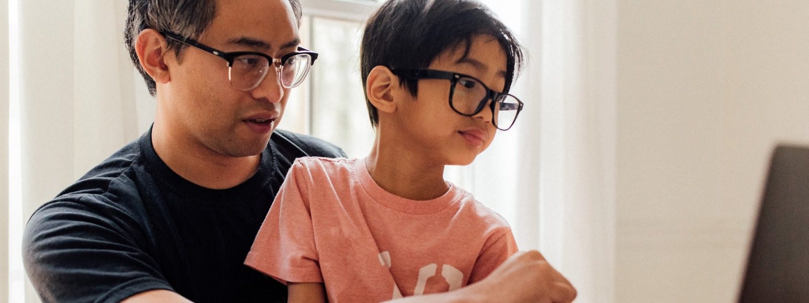 Kid and parent engaging in distance learning together