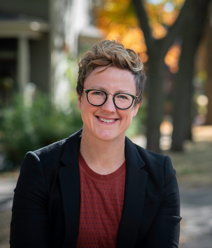 Headshot of Erin Walsh wearing a black blazer and rust colored shirt. Erin Walsh is the co-founder of Spark & Stitch Institute and author of the book It's Their World.