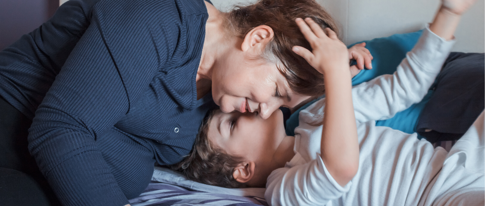 Parent tucking child into bed with family ritual