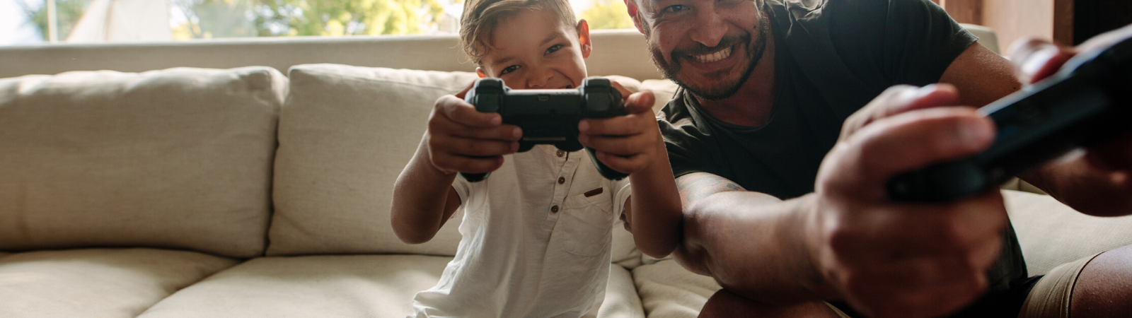 Dad and kid playing video games together on the couch