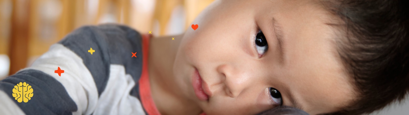 Child laying their head on the table looking at the camera sadly