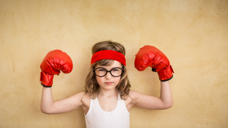 Child posing with strong muscles displaying growth mindset