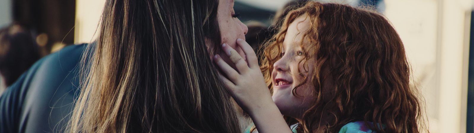 Young child looking up into her parent's face.