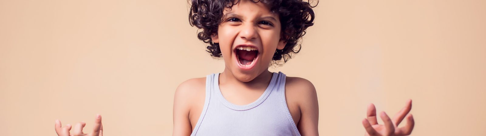 Child centered in a warm brown background expressing anger.