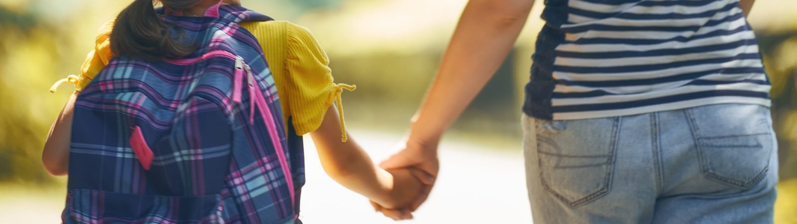 Parent holding their child's hand