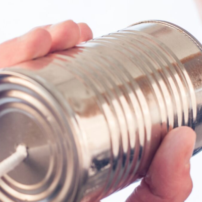 Person talking into tin can to symbolize communication
