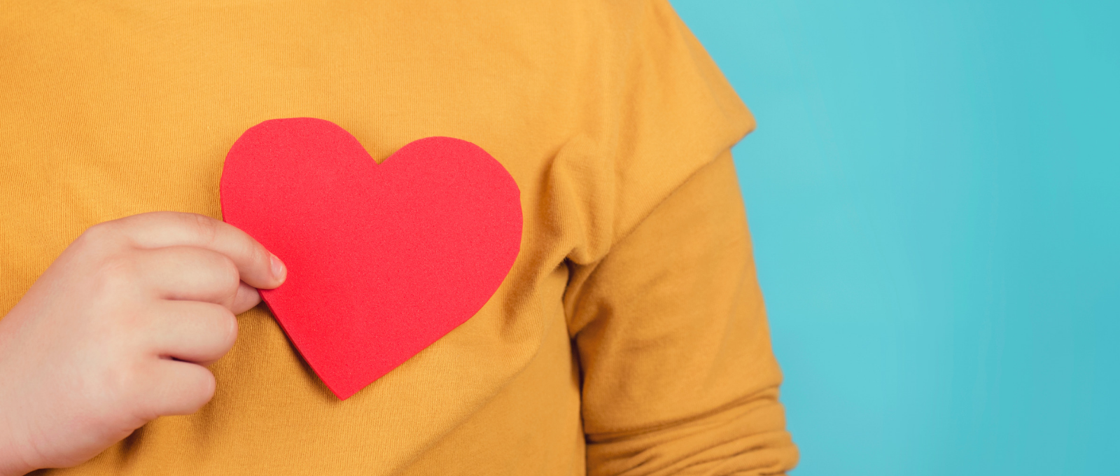 Person holding a heart over their chest to symbolize empathy