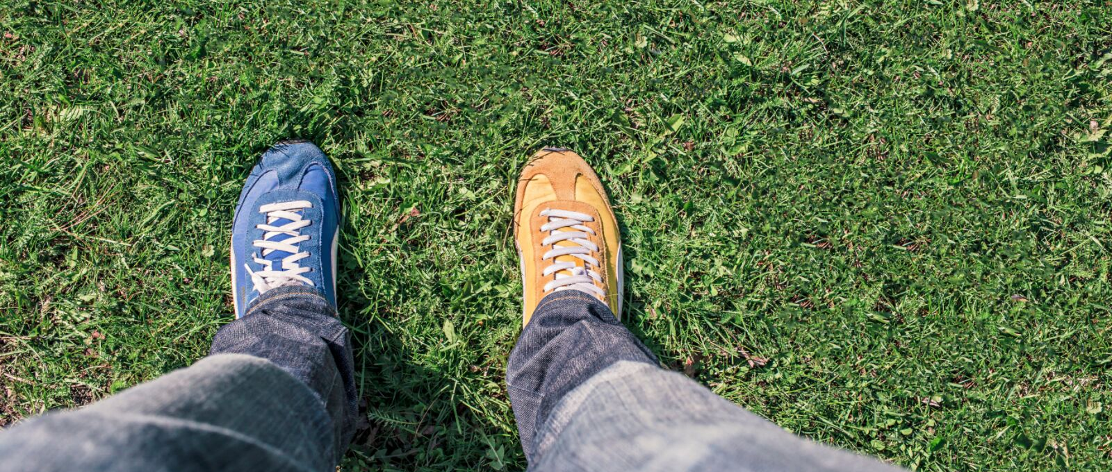 Looking down on two different color shoes to symbolize empathy, standing in someone else's shoes