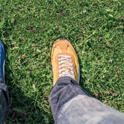 Looking down on two different color shoes to symbolize empathy, standing in someone else's shoes