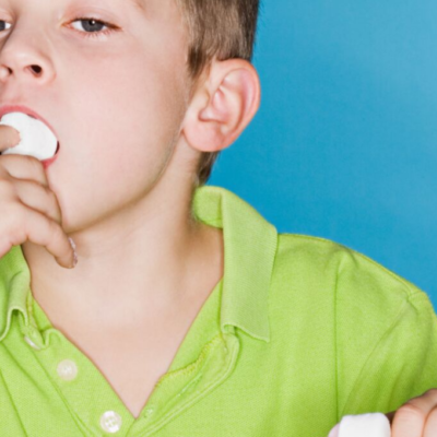 Child eating a marshmallow similar to Stanford University's famous "marshmallow experiment"
