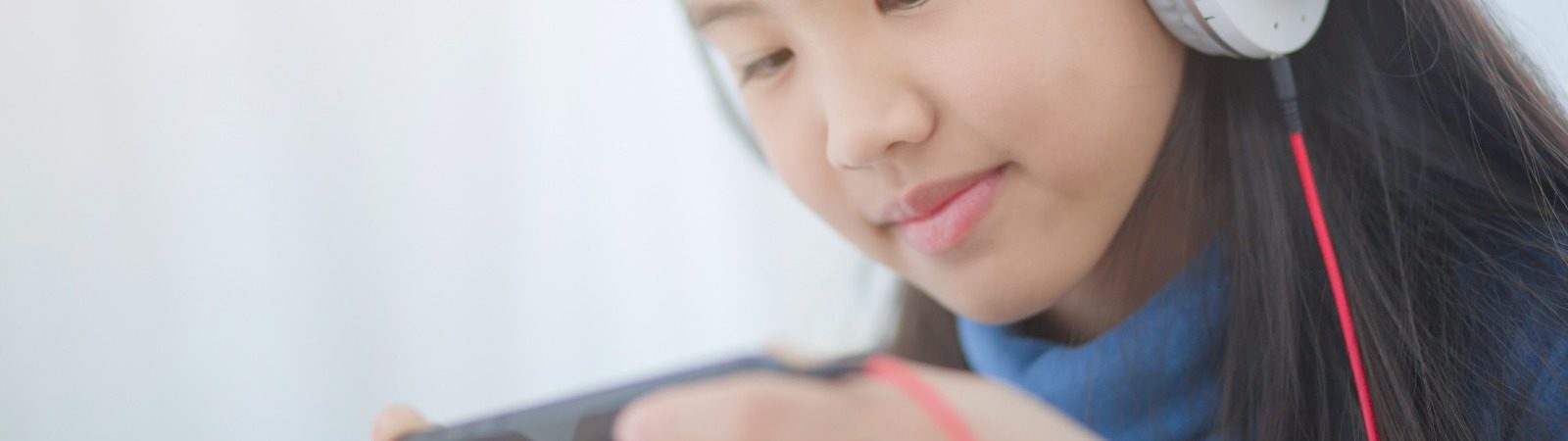 Teenager with headphones on looking at cell phone