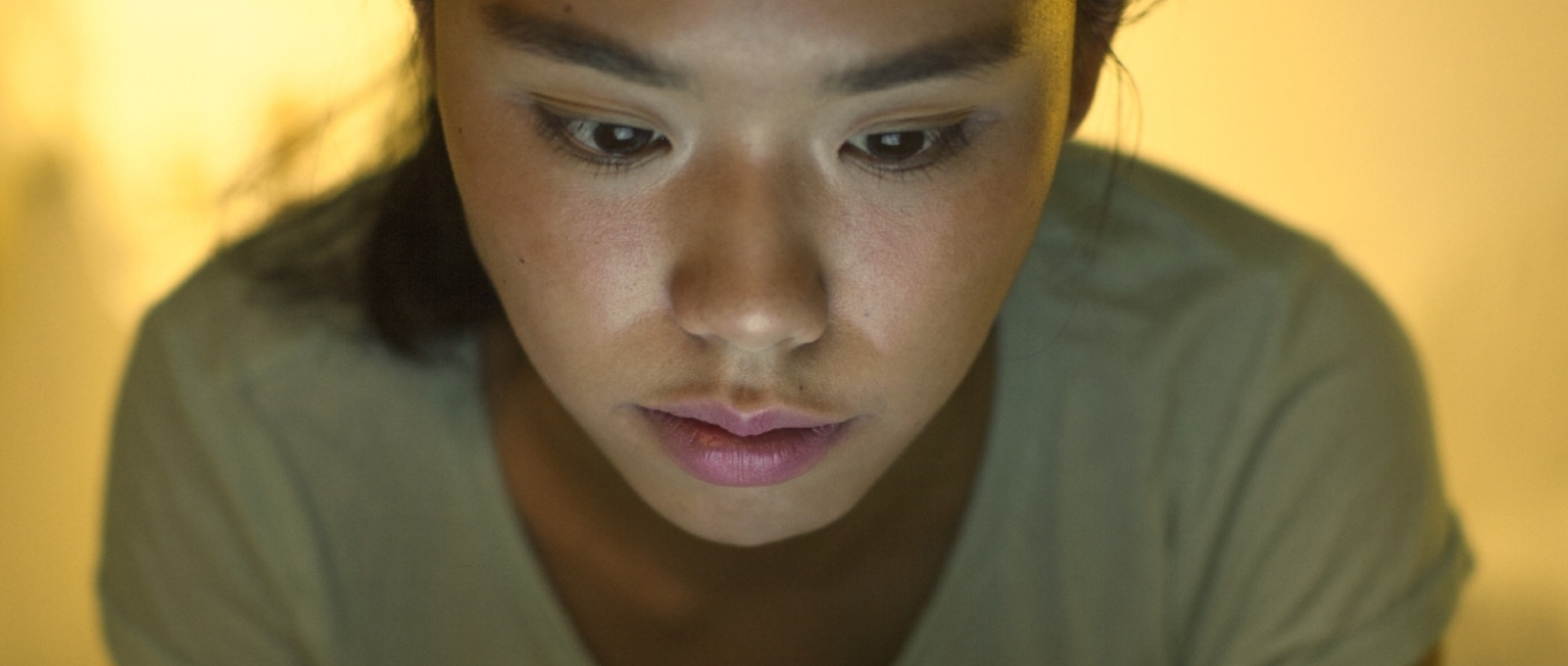 Teenager looking at glowing screen of ipad