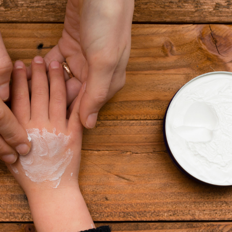 Parent helping child deal with stressful event by rubbing their hands.